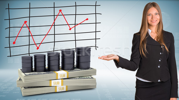Businesswoman points hand on barrels oil and money Stock photo © cherezoff