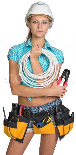 Pretty electrician in helmet, shorts, shirt, tool belt with tools holding an electric cable Stock photo © cherezoff