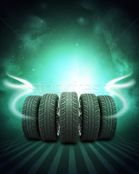 Wedge of new car wheels. Background is night sky and stripes at bottom Stock photo © cherezoff