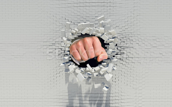 Fist punching through a brick wall Stock photo © cherezoff