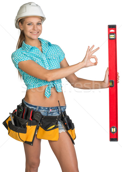 Beautiful girl in white helmet holding builder's level and showing OK hand sign Stock photo © cherezoff