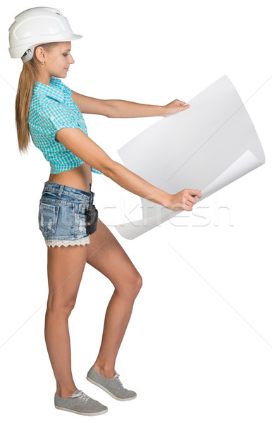 Beautiful woman builder holding in front of him large paper sheet Stock photo © cherezoff