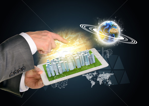 Man hands using tablet pc. Business city on touch screen. Earth near computer Stock photo © cherezoff