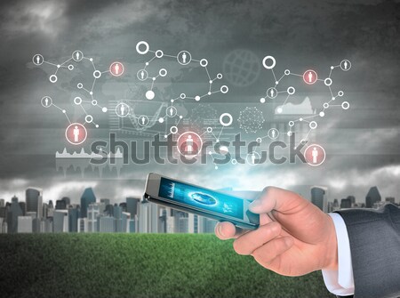 Hand holds city of skyscrapers on green grass and businessman walking forward. Flying letters, netwo Stock photo © cherezoff