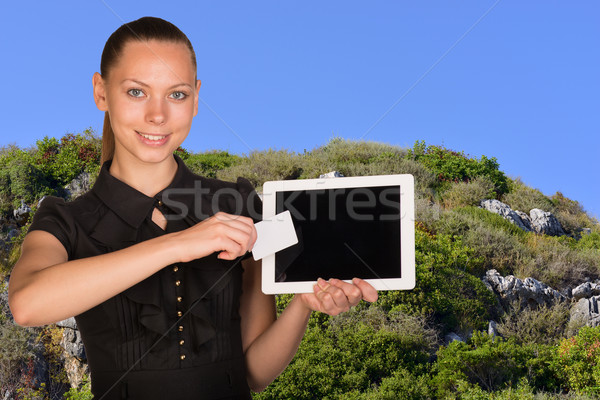 Beautiful businesswoman holding tablet PC. Blue sky and green hillside as backdrop Stock photo © cherezoff