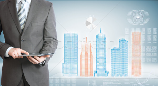 Stock photo: Businessman with tablet pc. High-tech skyscrapers