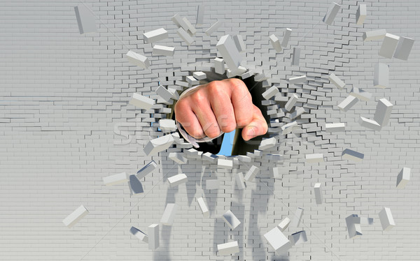 Fist punching through brick wall Stock photo © cherezoff