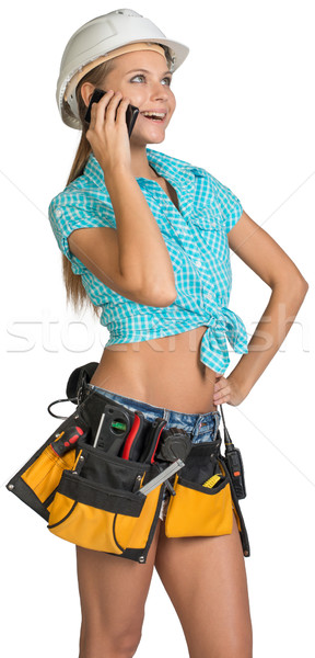 Woman in hard hat and tool belt calling on mobile phone Stock photo © cherezoff