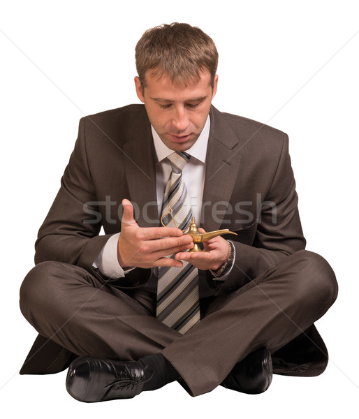 Businessman sitting and hold gold lamp Stock photo © cherezoff