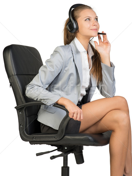 Businesswoman in headset sitting on office chair Stock photo © cherezoff