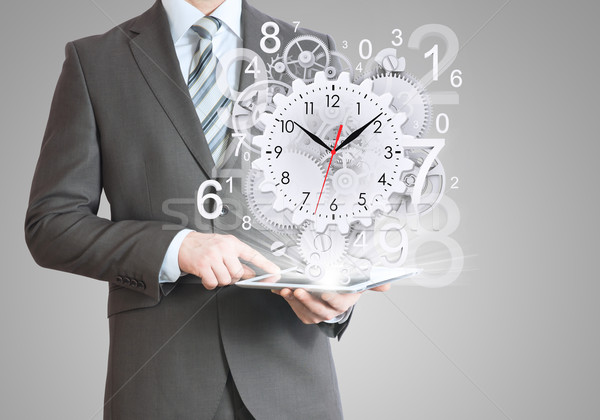 Businessman hold tablet pc with clock and gears Stock photo © cherezoff