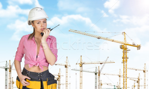 Woman in hard hat and tool belt talking on walkie talkie Stock photo © cherezoff