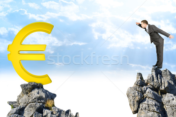 Businessman standing on edge of rock mountain  Stock photo © cherezoff