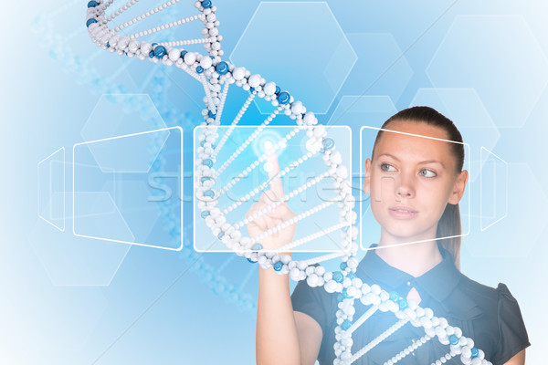 Beautiful businesswoman in dress presses finger on model of DNA Stock photo © cherezoff