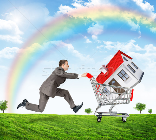 Running businessman with house in shopping cart Stock photo © cherezoff