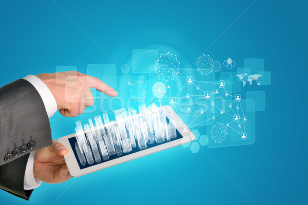 Stock photo: Man hands using tablet pc. Wire-frame buildings on touch screen. Virtual elements near computer