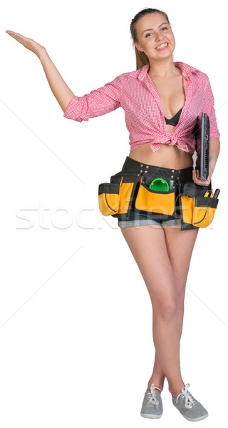 Woman in tool belt, with laptop under her armpit, showing empty palm Stock photo © cherezoff