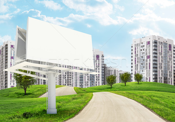 Blank billboard by road running through green hills towards city Stock photo © cherezoff