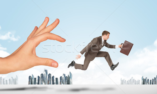 Hand catching businessman running forward Stock photo © cherezoff