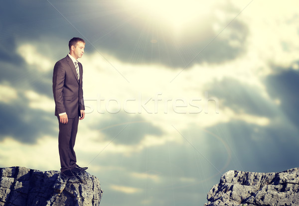 Biznesmen stałego krawędź rock luka patrząc w dół Zdjęcia stock © cherezoff