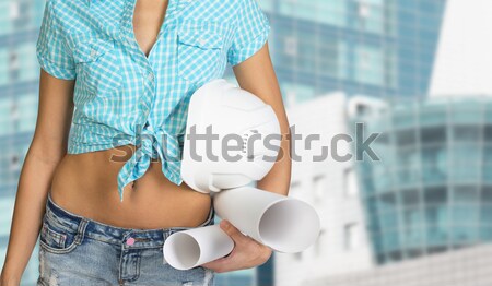 Nice sexy woman holding scrolls of paper and white helmet. In a cropped photo Stock photo © cherezoff