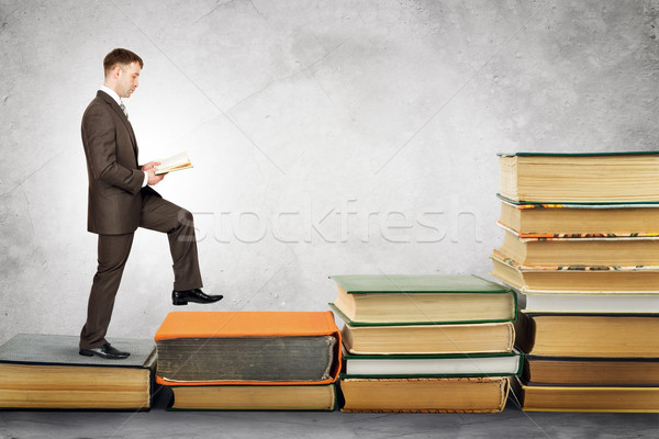 Businessman reading book and walks up Stock photo © cherezoff