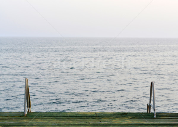 Wooden pier with metal handrails Stock photo © cherezoff