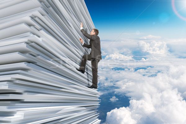 Businessman climbing up a huge stack of paper Stock photo © cherezoff