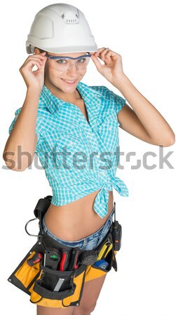 Stock photo: Beautiful girl in white helmet, shorts with shirt holding scrolls drawings and talking on walkie-tal