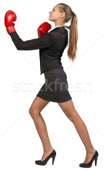 Stock photo: Businesswoman wearing boxing gloves punching