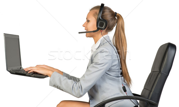 Geschäftsfrau Headset eingeben Laptop-Tastatur Sitzung Bürostuhl Stock foto © cherezoff