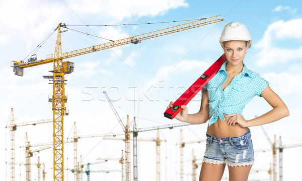 Woman in hard hat with large builders level on her shoulder Stock photo © cherezoff