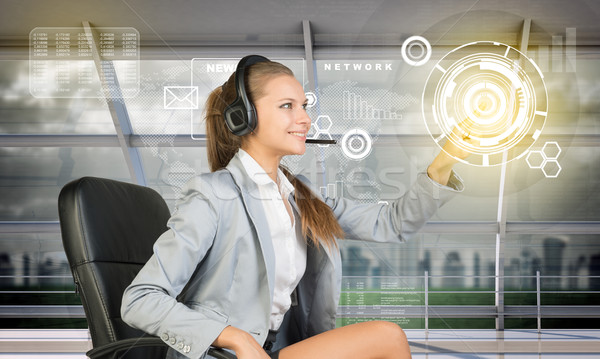 Smiling businesslady touching holographic screen Stock photo © cherezoff