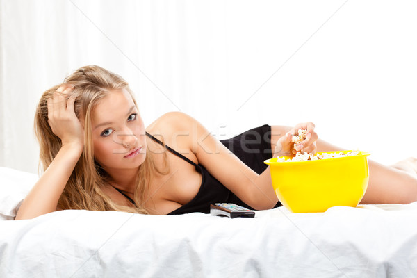 Frau Bett Essen Popcorn beobachten Stock foto © chesterf