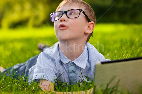 funny boy laying on grass in the park with laptop Stock photo © chesterf