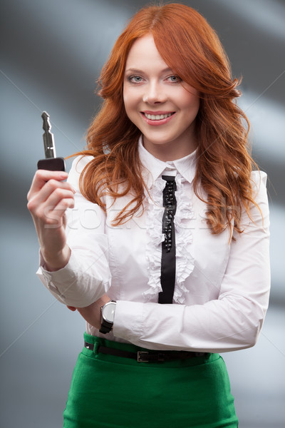 Stock photo: happy woman holding big key