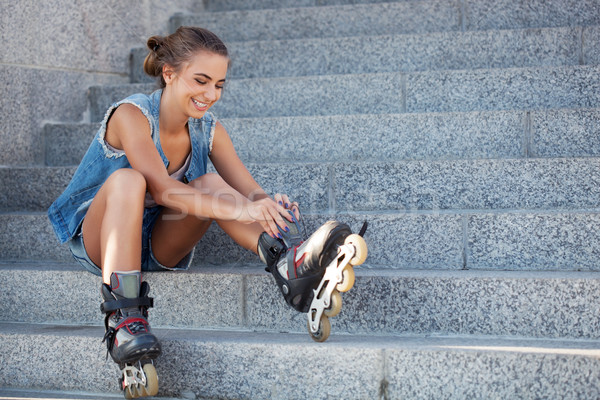 girl sitting on the stairs and puts on skates Stock photo © chesterf