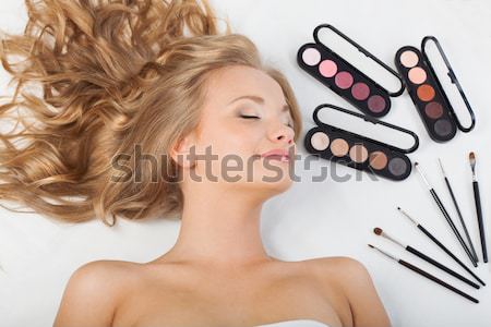 woman laying on floor with eyeshadows and brushes Stock photo © chesterf