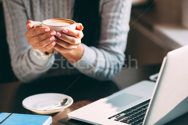 Woman holds hot cup of coffee, warming her hands Stock photo © chesterf