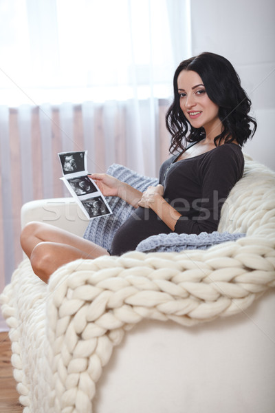 happy beautiful pregnant woman relaxing on sofa with echo in hands Stock photo © chesterf