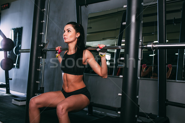 sportsy woman doing squats with a barbell in Smith machine  Stock photo © chesterf