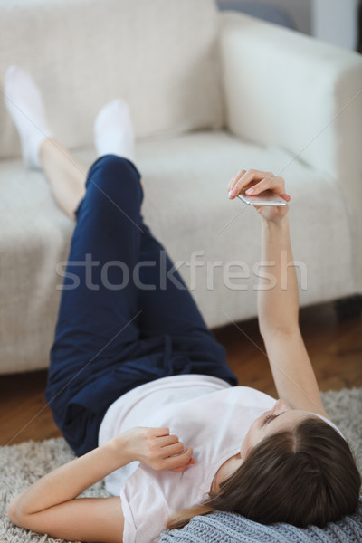 [[stock_photo]]: Jeune · femme · tapis · maison · jambes · canapé