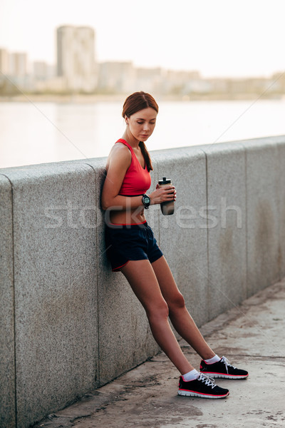 Female runner with bottled water tired Stock photo © chesterf