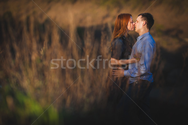 couple kissing standing outdoos among bushes Stock photo © chesterf