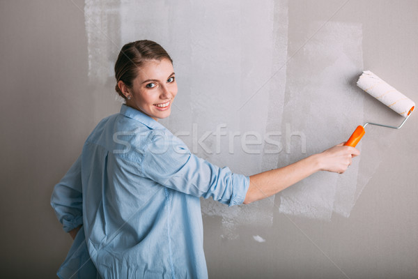 Beautiful young woman doing wall painting Stock photo © chesterf