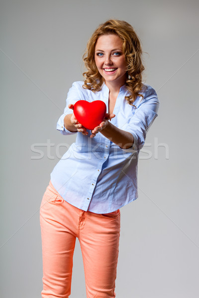 Stock photo: happy woman holding heart symbol