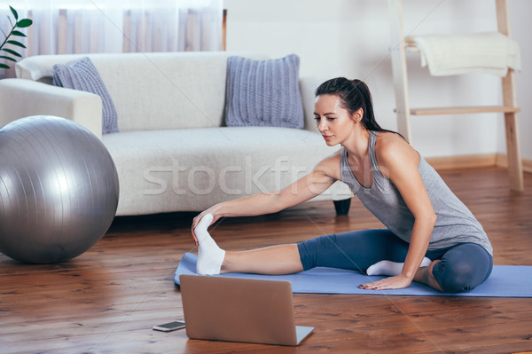 Beautiful young woman doing yoga at home. Stock photo © chesterf