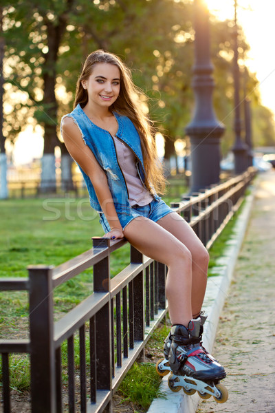 roller girl wearing jeans sitting on iron fence Stock photo © chesterf