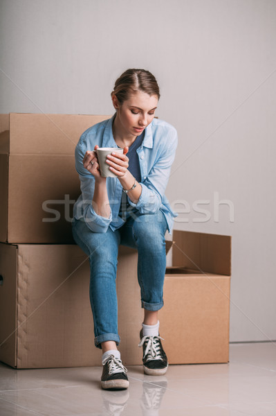 Beautiful tired girl sitting on box is looking to the floor Stock photo © chesterf