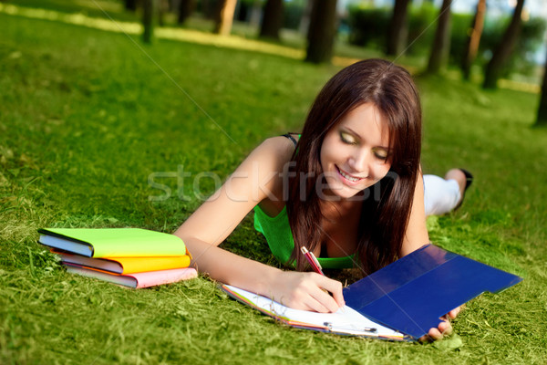 woman laying on grass and writing Stock photo © chesterf